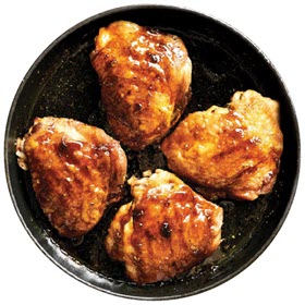 Bell & Evans Chicken Thighs shown roasted in a cast iron skillet on a white background.