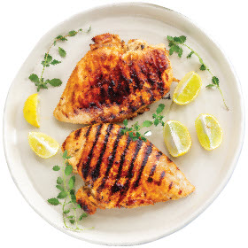 Two Perdue Boneless Skinless Chicken Breasts shown grilled and served on a plate with wedges of lemon, ready to be enjoyed.