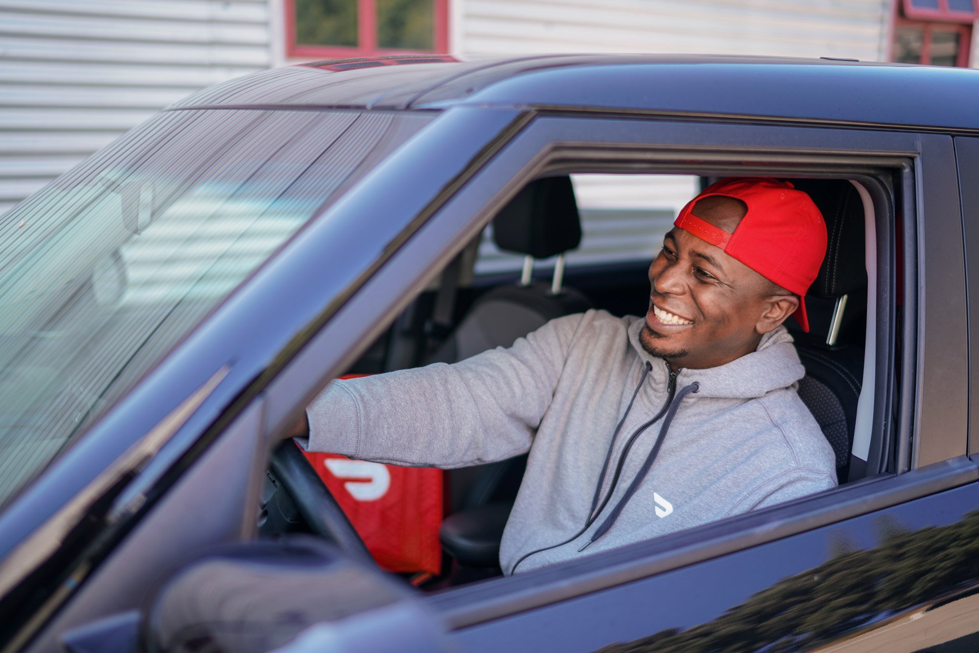 A DoorDash Driver in his car, on his way to deliver groceries to a customer.